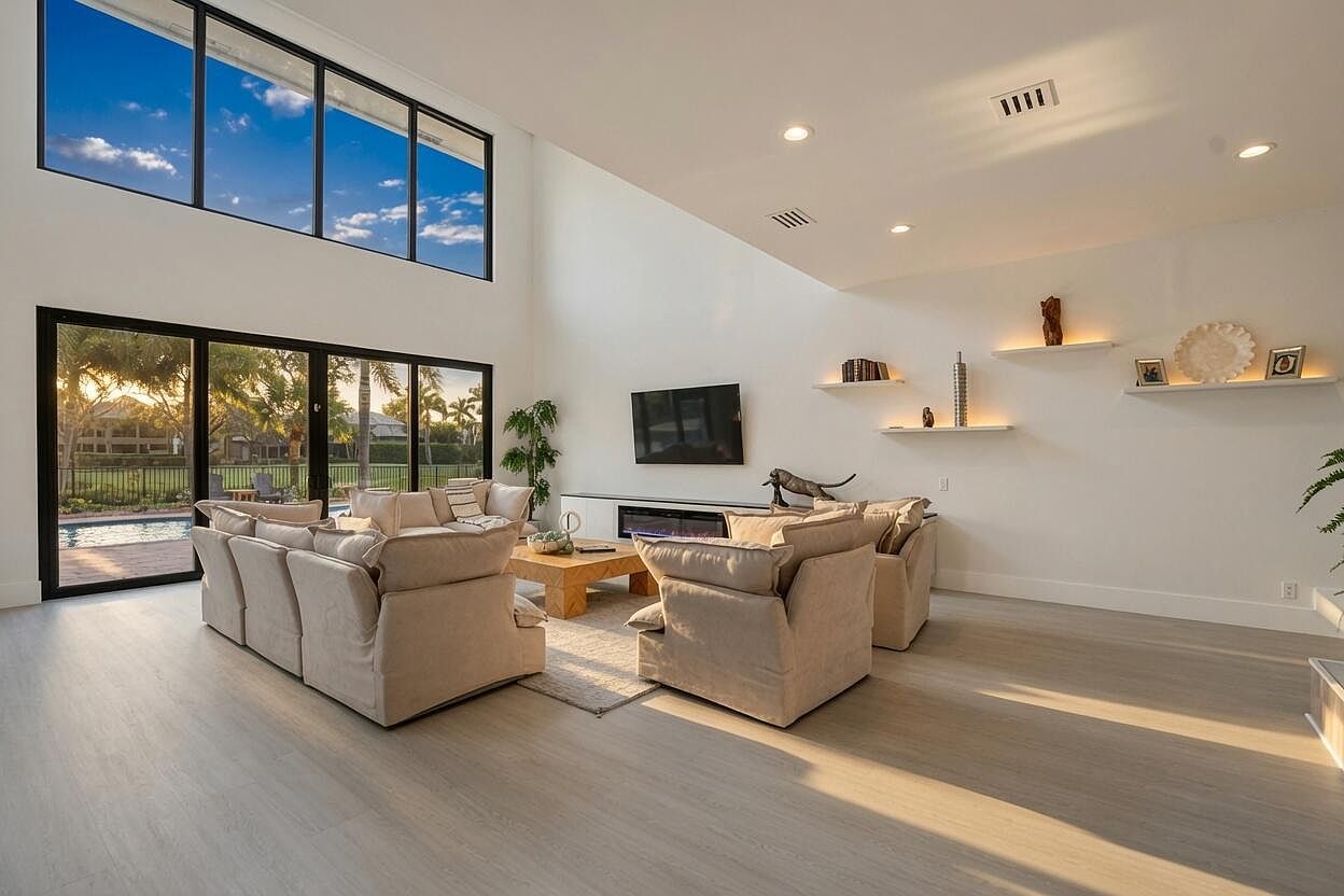 Two-story great room with clerestory windows, sectional seating and views of the golf course
