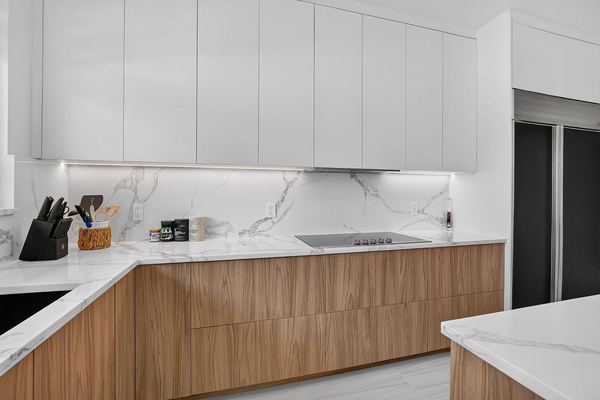 Kitchen cooktop run with a marble backsplash and flat-panel cabinetry