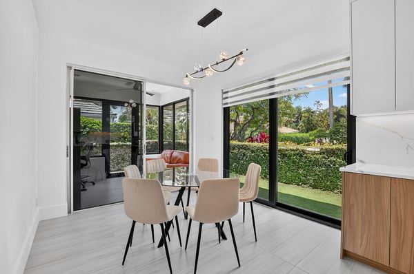 Breakfast nook with a round table and floor-to-ceiling windows to the garden