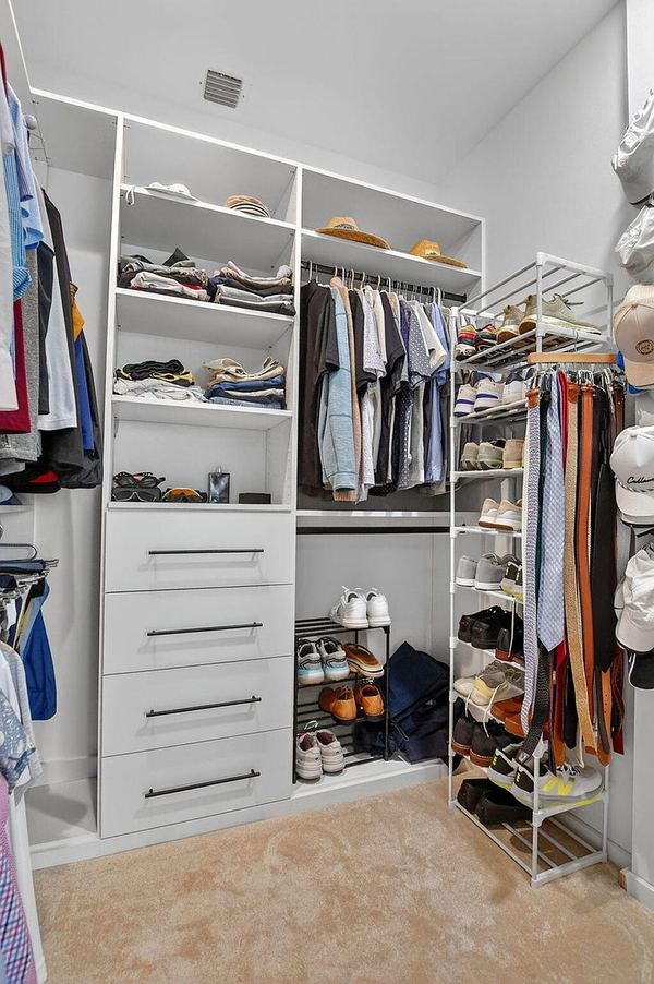 Primary walk-in closet with built-in shelving and drawers