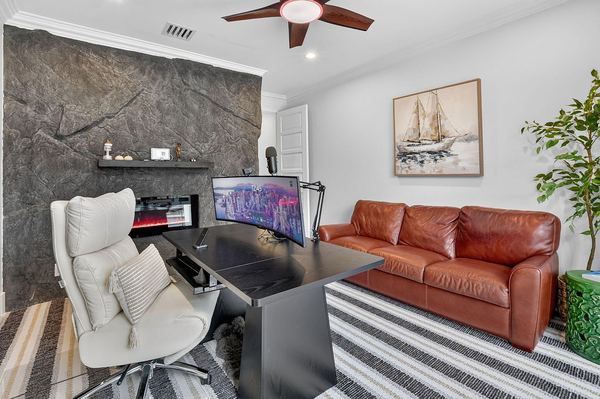 Study with a stone feature wall, a leather sofa and an executive desk