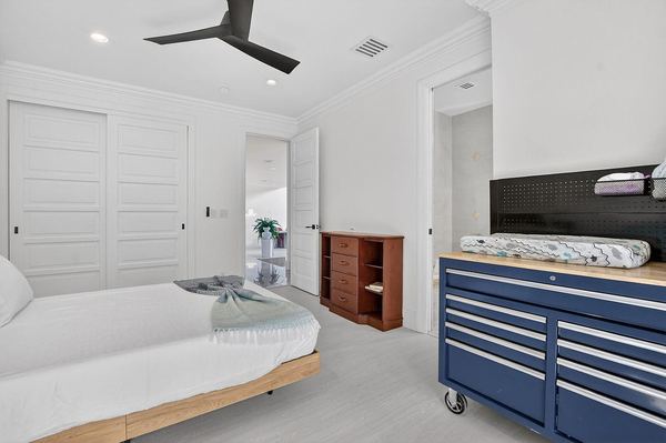 Bedroom with a built-in closet, a ceiling fan and storage