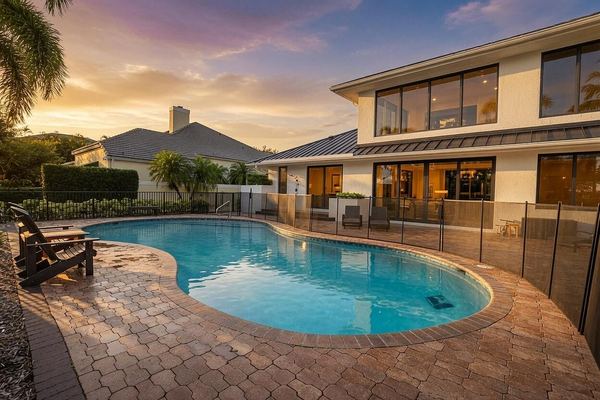 Pool and the rear of the home at dusk, with the safety fence