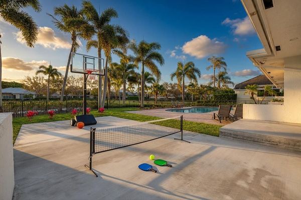 Side-yard sport court with a basketball hoop and a game net