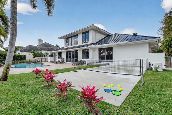 Rear exterior with lawn, sport court and the metal roof