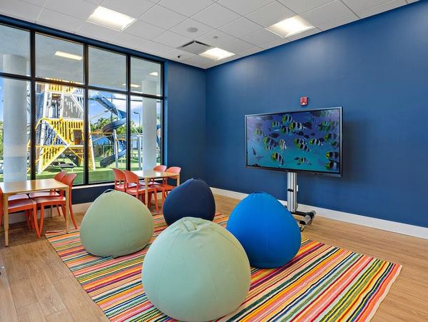 Kids' club room with bean bags and a TV